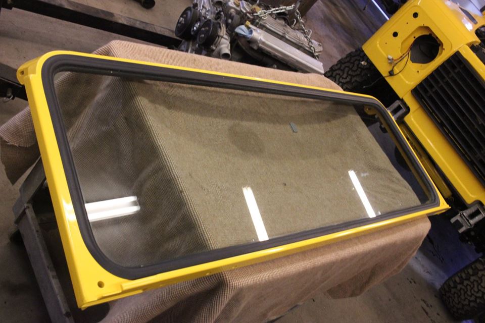A new windshield is installed in the repainted frame with a new genuine Land Rover gasket.