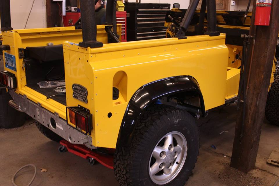 The rear tub is assembled. New genuine Land Rover fender flares are used; these appear glossy when new but fade to a matte black.